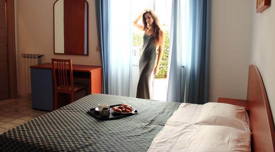 foto in una colazione in camera su vassoio e di donna al risveglio cliente dell'hotel costa citara di forio